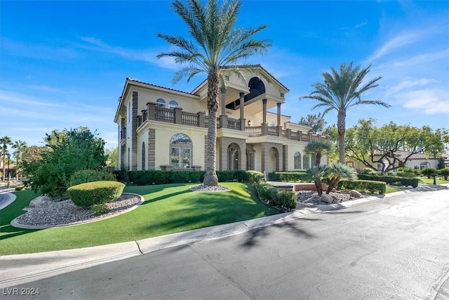 view of front of property with a balcony and a front yard