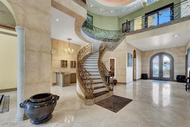 foyer featuring french doors, a high ceiling, and a notable chandelier