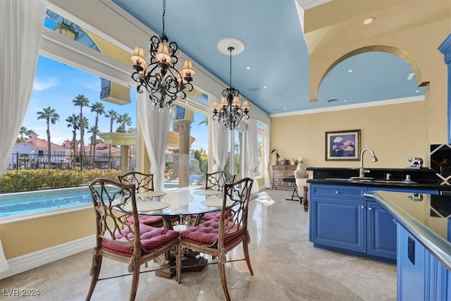 dining area featuring ornamental molding, sink, and a chandelier