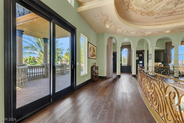 doorway to outside with dark hardwood / wood-style flooring and a tray ceiling