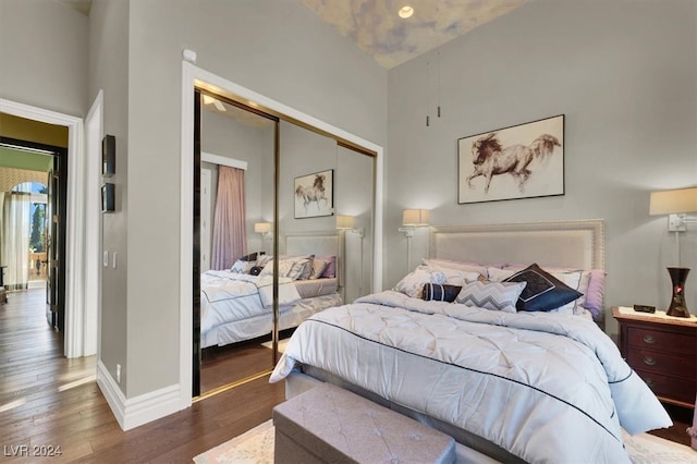 bedroom with dark hardwood / wood-style floors, vaulted ceiling, and a closet