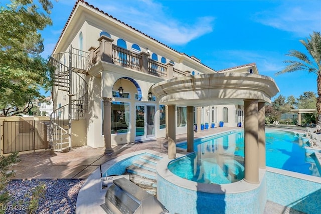 back of house with a fenced in pool, a patio area, and a balcony