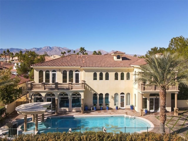 back of house featuring a mountain view, a fenced in pool, and a patio area