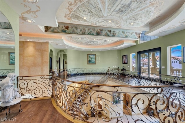 interior space with hardwood / wood-style flooring and a raised ceiling