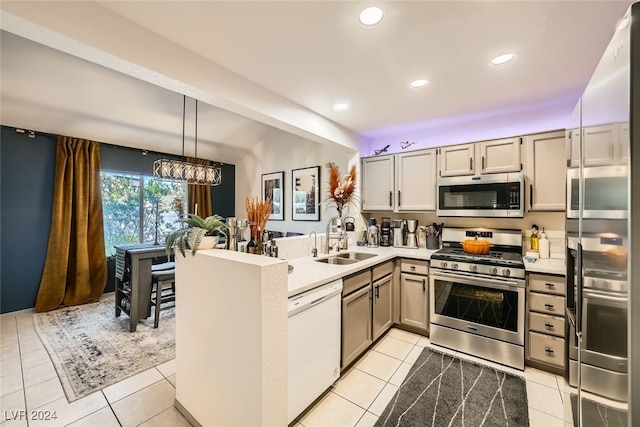 kitchen featuring sink, kitchen peninsula, appliances with stainless steel finishes, light tile patterned floors, and hanging light fixtures