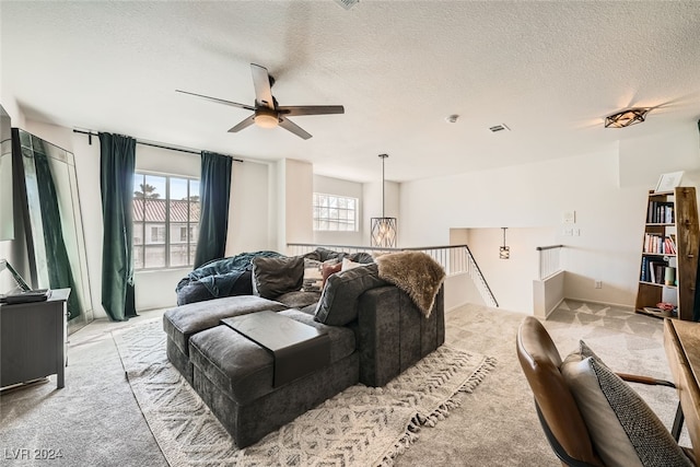 living room featuring a textured ceiling, light carpet, and ceiling fan