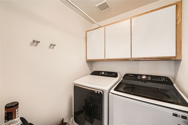 laundry room with cabinets and washer and dryer