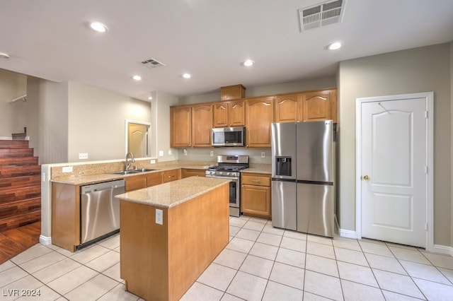 kitchen featuring stainless steel appliances, light tile patterned flooring, sink, light stone counters, and a kitchen island