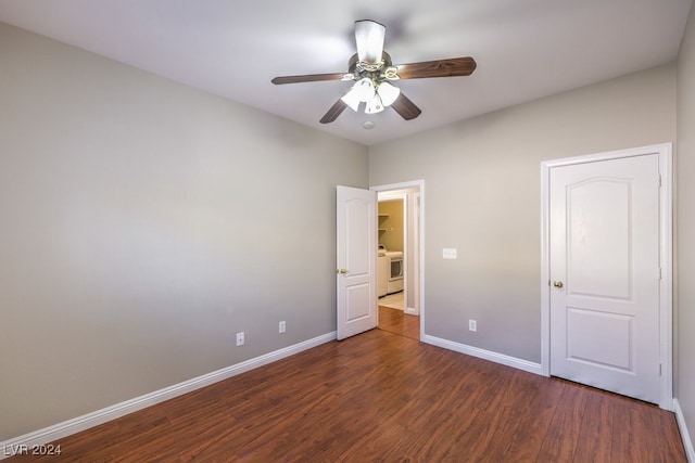 unfurnished bedroom featuring ceiling fan, washer / clothes dryer, and dark hardwood / wood-style flooring