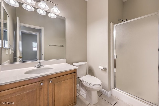 bathroom featuring tile patterned flooring, vanity, toilet, and a shower with door