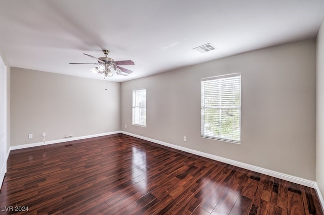 unfurnished room featuring dark wood-type flooring, a wealth of natural light, and ceiling fan