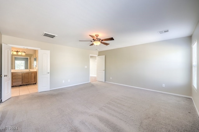 interior space featuring light carpet and ceiling fan