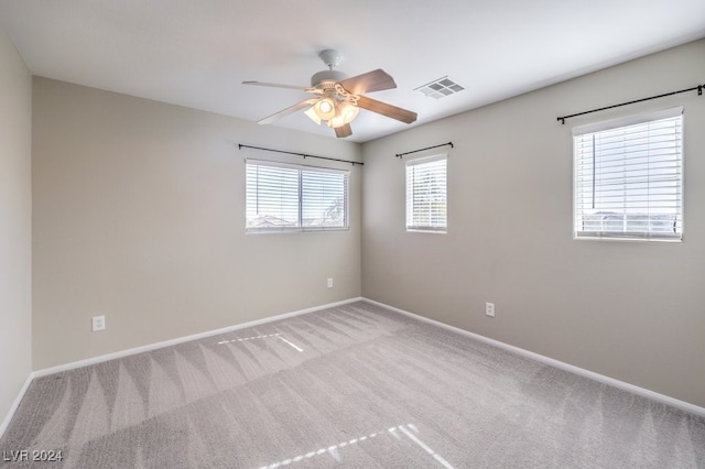 unfurnished room with light colored carpet and ceiling fan