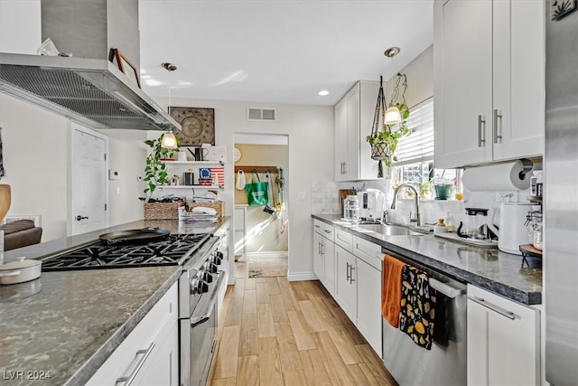 kitchen featuring stainless steel appliances, white cabinetry, and decorative light fixtures