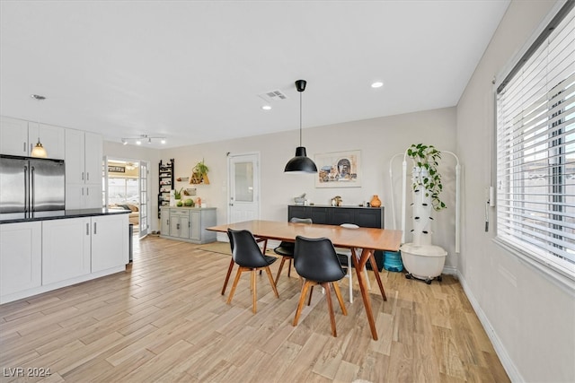 dining area with a wealth of natural light and light hardwood / wood-style floors