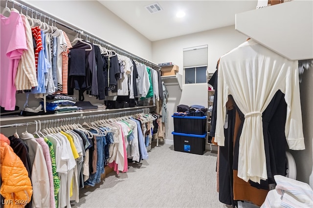 walk in closet with light colored carpet