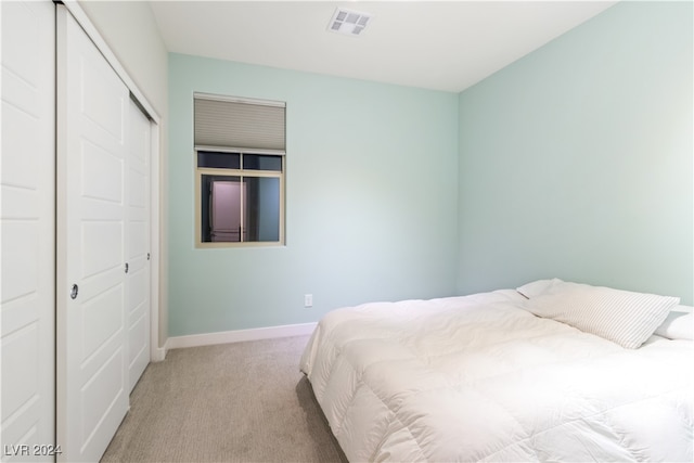 bedroom featuring light carpet and a closet