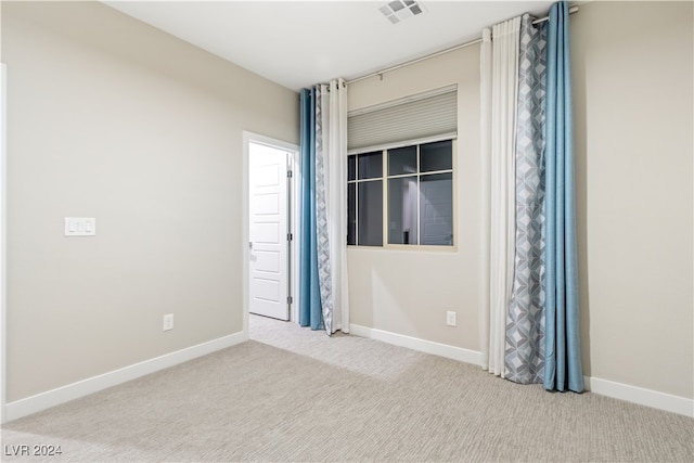 spare room featuring light colored carpet