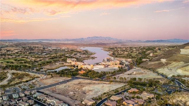 aerial view at dusk featuring a water view