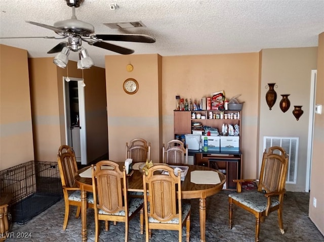 dining space featuring ceiling fan, a textured ceiling, and dark colored carpet