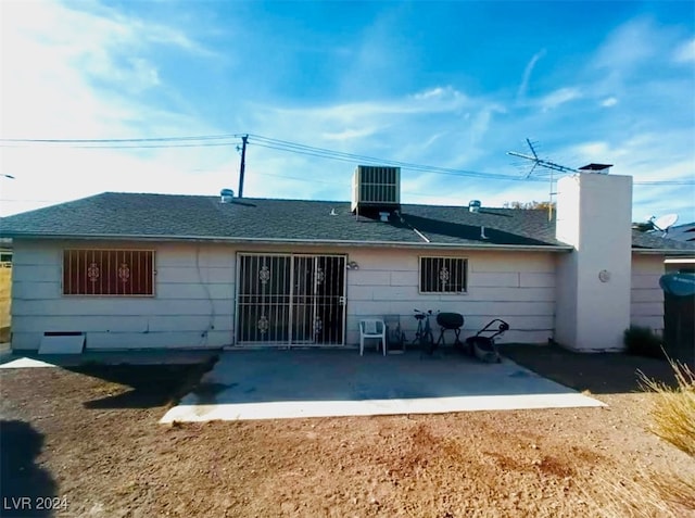 back of property with central air condition unit and a patio