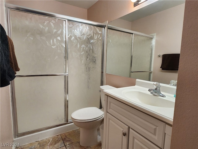 bathroom with a shower with shower door, vanity, and toilet