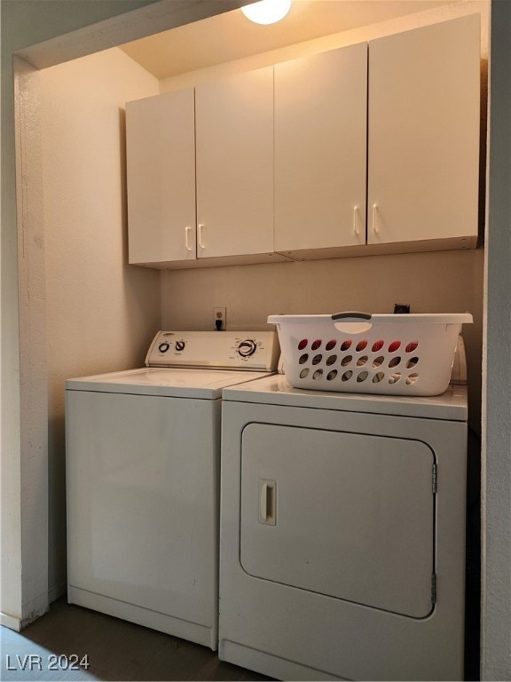 clothes washing area featuring cabinets and separate washer and dryer