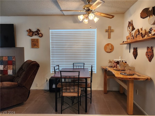 dining area featuring ceiling fan and a textured ceiling