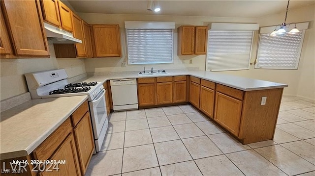 kitchen with pendant lighting, sink, white appliances, and light tile patterned floors