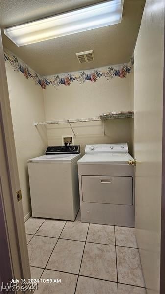 washroom with washer and dryer and light tile patterned floors