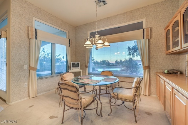 carpeted dining area featuring a chandelier