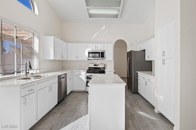 kitchen with a kitchen island, white cabinets, sink, and stainless steel appliances