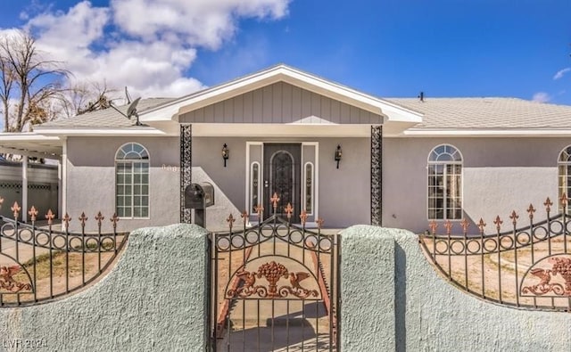 view of front of house featuring a fenced front yard, a gate, and a shingled roof