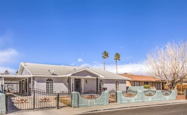 ranch-style home with an attached carport, a fenced front yard, a gate, and stucco siding