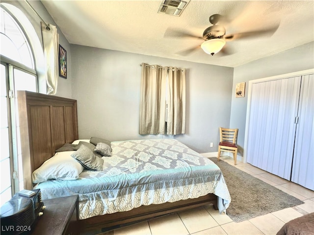 tiled bedroom featuring a textured ceiling and ceiling fan