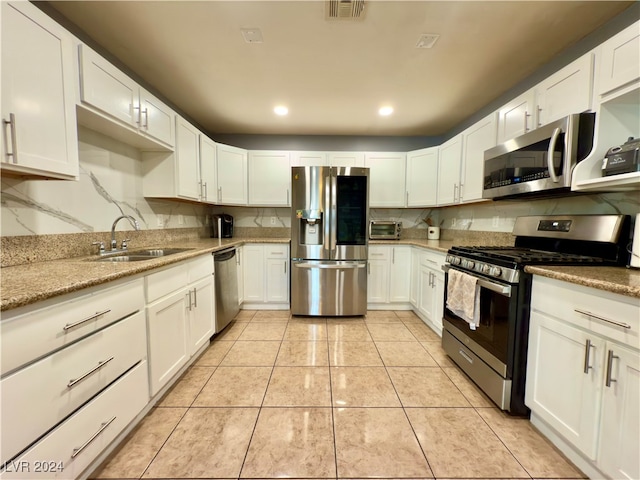 kitchen featuring white cabinets, light tile patterned flooring, sink, and appliances with stainless steel finishes