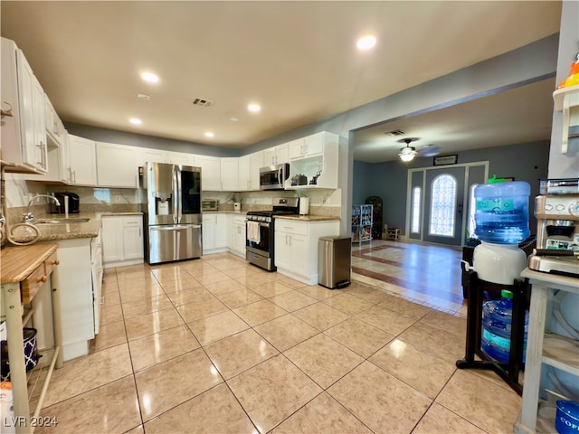 kitchen featuring white cabinets, stainless steel appliances, ceiling fan, and sink