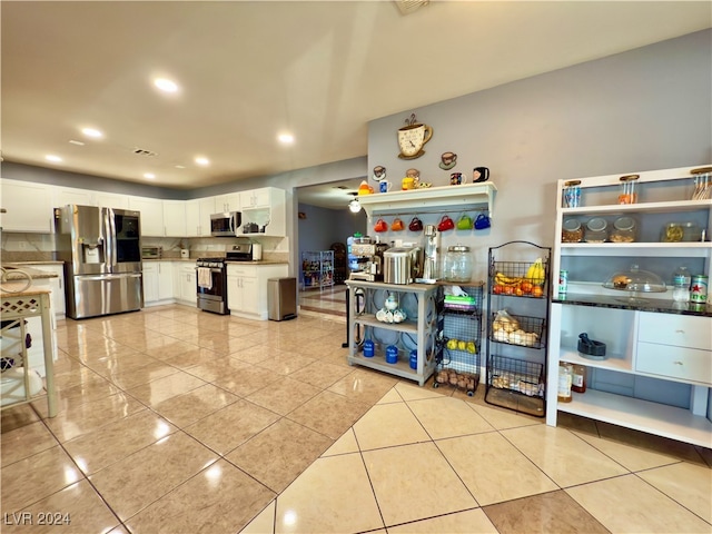 kitchen with white cabinets, backsplash, light tile patterned floors, and stainless steel appliances