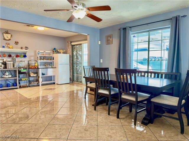 tiled dining space with a wealth of natural light, ceiling fan, and a textured ceiling