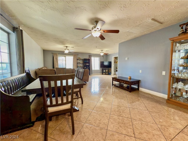 dining room featuring a textured ceiling, ceiling fan, and light tile patterned flooring