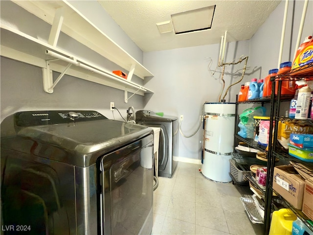 laundry room with washer and clothes dryer, strapped water heater, and a textured ceiling