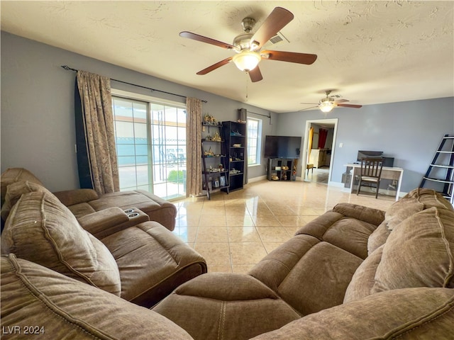 tiled living room featuring ceiling fan and a textured ceiling