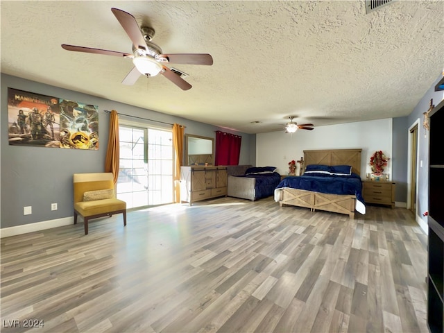 bedroom featuring ceiling fan, hardwood / wood-style floors, and a textured ceiling