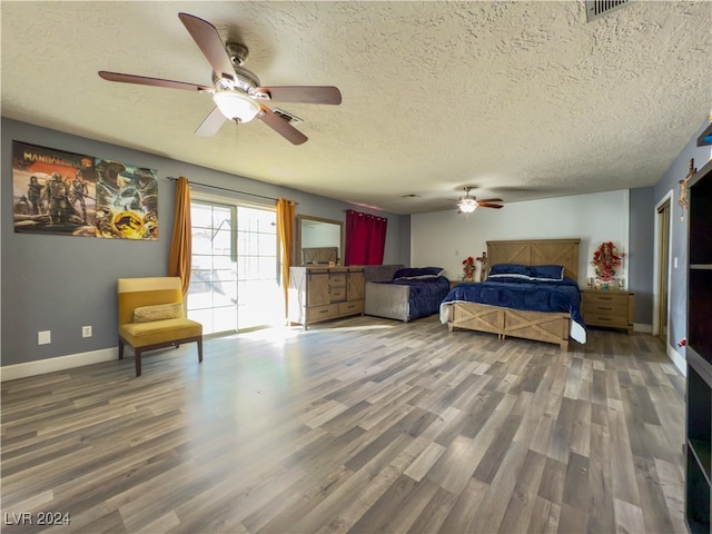 bedroom with ceiling fan, a textured ceiling, and hardwood / wood-style flooring