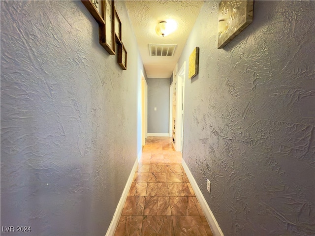 hall with a textured ceiling