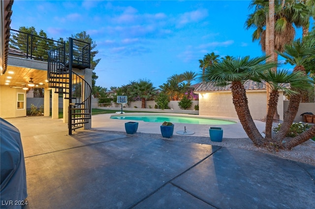 pool at dusk with a patio area