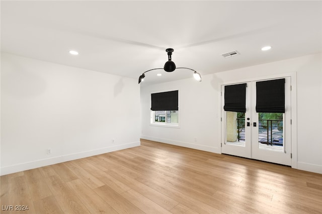 unfurnished living room with light hardwood / wood-style floors, a healthy amount of sunlight, and french doors