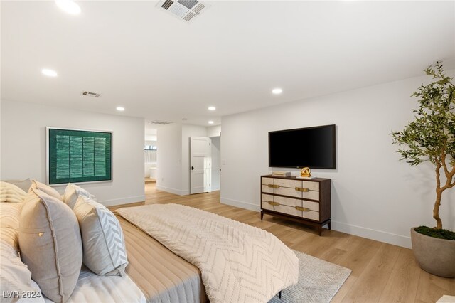 bedroom featuring ensuite bathroom and light hardwood / wood-style flooring