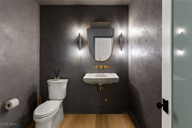 bathroom featuring wood-type flooring and toilet