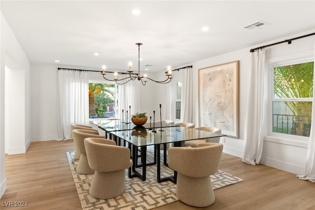 dining room featuring a wealth of natural light, an inviting chandelier, and light wood-type flooring